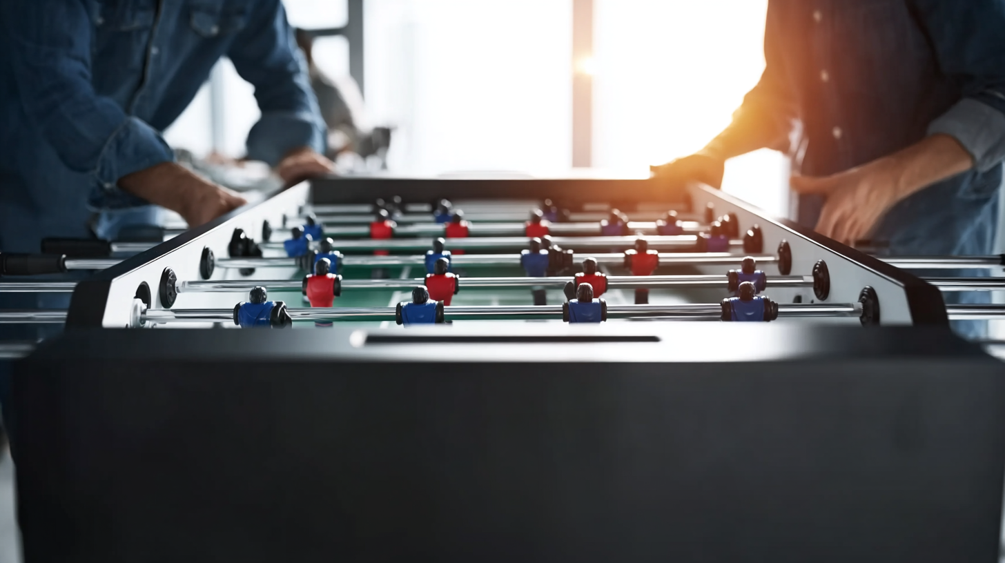 Twee collega’s spelen tafelvoetbal tijdens een pauze op kantoor