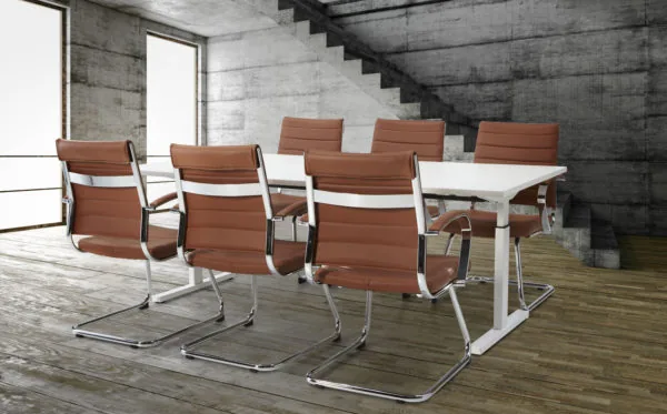 Vergaderstoelen van bruin leer met chromen frame rond witte vergadertafel in moderne kantoorruimte
